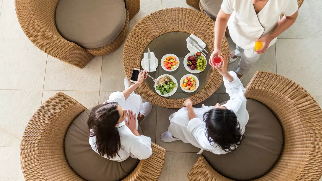 Therapist Serving Fresh Juice to Two Women