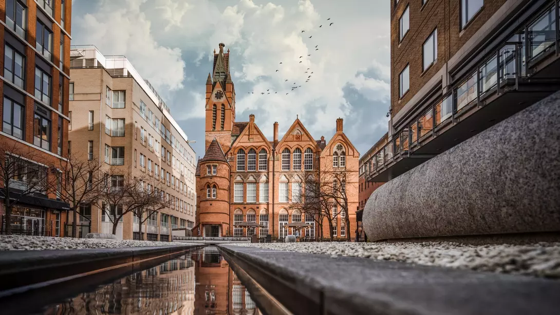 Brindley Place red brick church building reflected in water. West Midlands landmark buildings redevelopment in historic city centre reflection in stream.