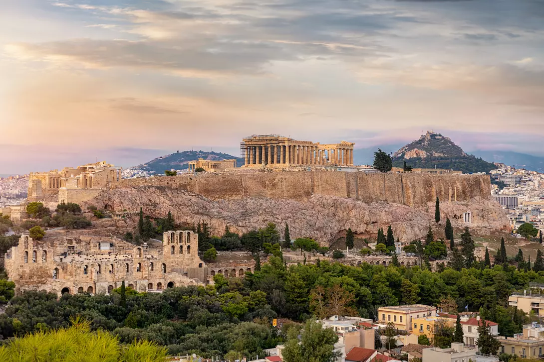 View to the Acropolis of Athens on top of the old town Plaka during a cloudy summer sunset, Greece