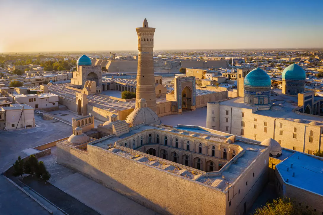 Sunset over the famous Kalyan Poi Kalon Minaret, Poi Kalan or Po-i-Kalyan and Mir Arab Madrasah in the center of the old town of Bukhara