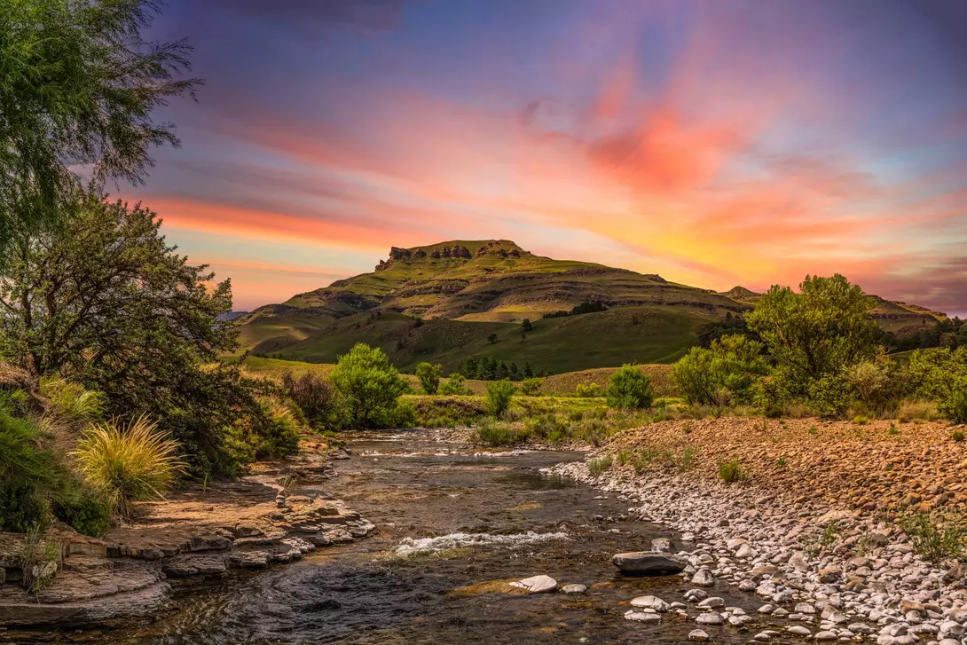 Drakensberg valley and a river running through it during sunset