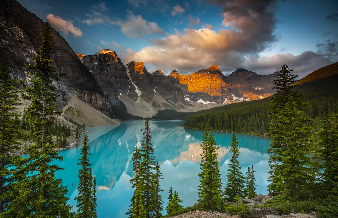 Moraine Lake in Banff National Park at sunset. Mountains of famous Ten Peaks reflecting in the beautiful calm turquoise water of the lake