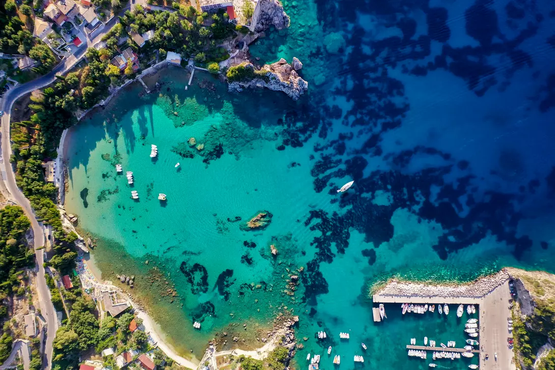 Aerial view of the beautiful Corfu coastline, showing deep blue colours of the Mediterranean Sea