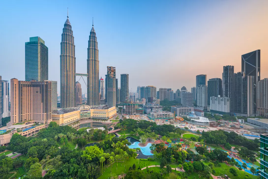 Sunset skyline view of Kuala Lumpur featuring the Petronas Twin Towers, an interlinked pair of 88-storey skyscrapers 