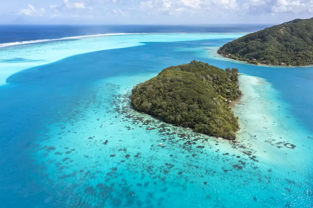A deep, crystal-clear lagoon surrounds the two islands, while magnificent bays and white-sand beaches add drama