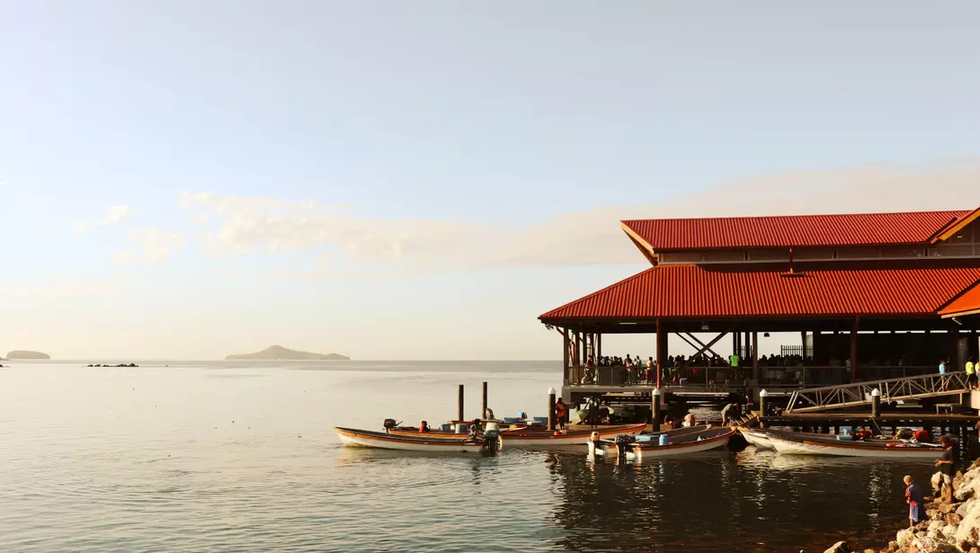 Boats on dock beside oceanside Papua New Guinea market
