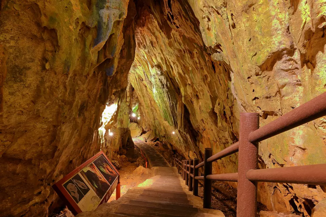 Stairs descend underneath natural rock and caves
