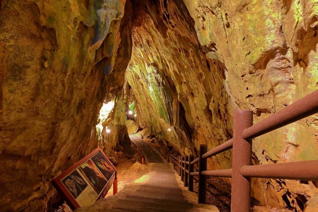Stairs descend underneath natural rock and caves