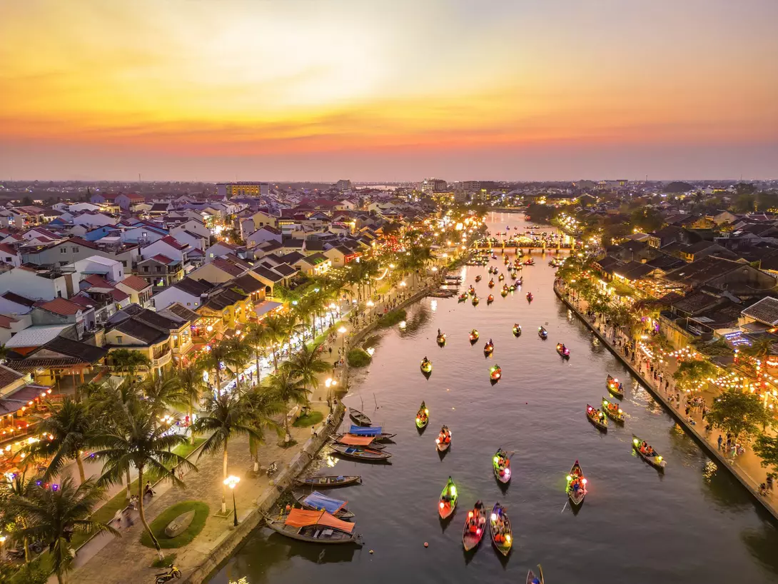 Hoi An at dusk with boats cruising on Thu Bon River with lanterns