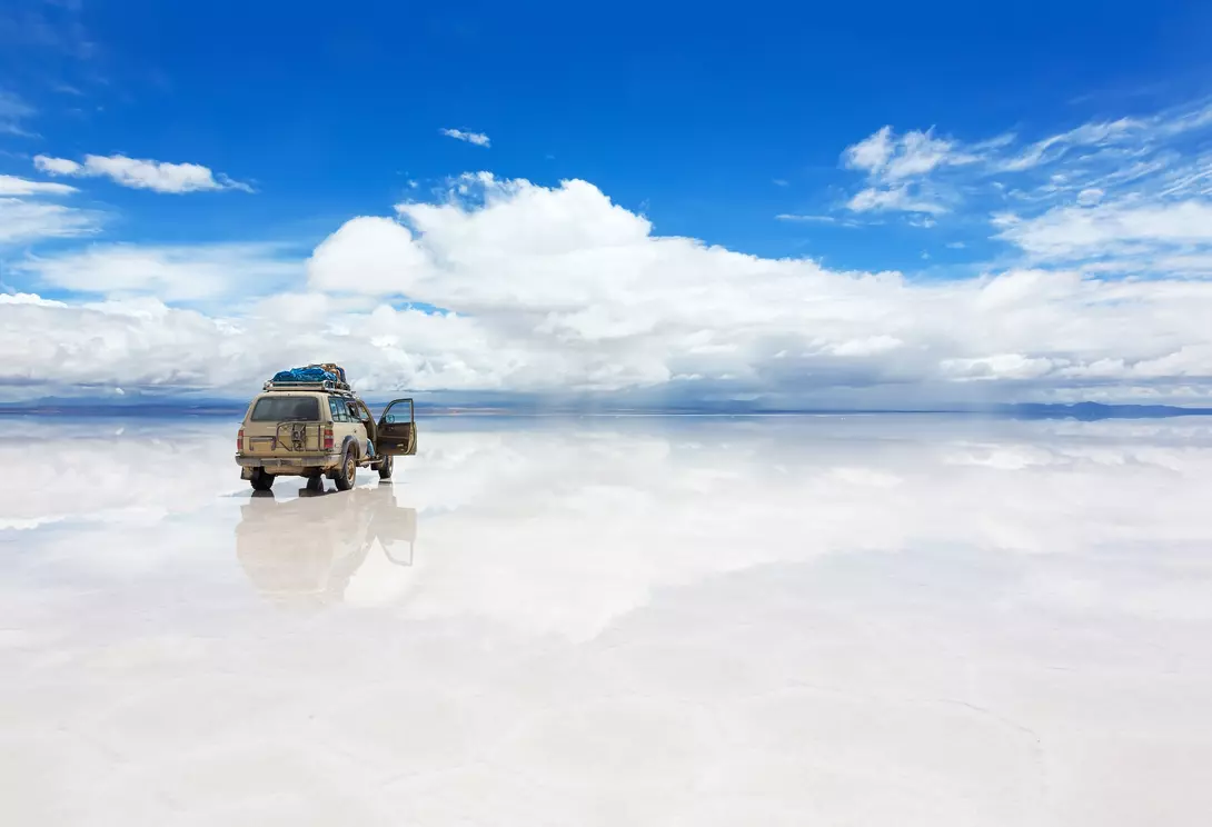 The world's largest salt flat, Salar de Uyuni in Bolivia, with Jeep vehicle driving over