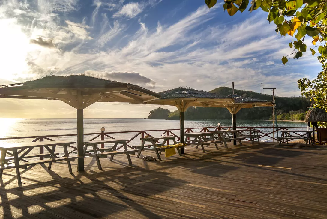 A group of picnic tables over look the beautiful pacific ocean sunset in Fiji 