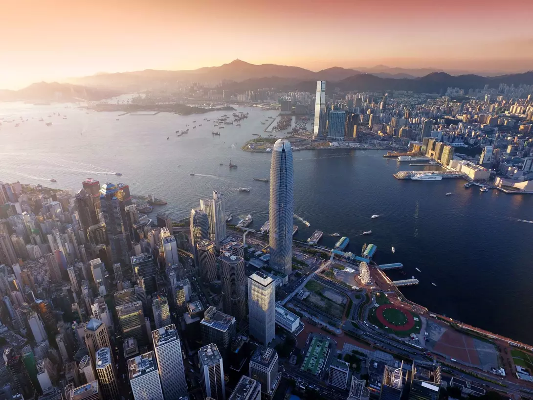 Dramatic skyline of Hong Kong Island and busy ships navigates across the Victoria Harbour during beautiful sunset