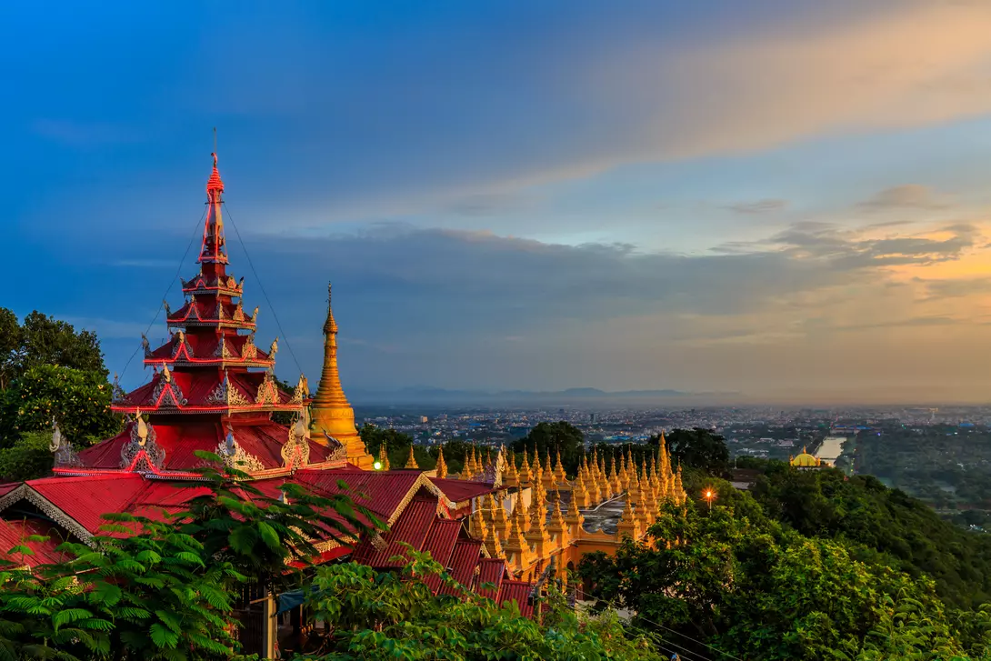 HIllside view of the red roof of Mandalay Palace and Hill