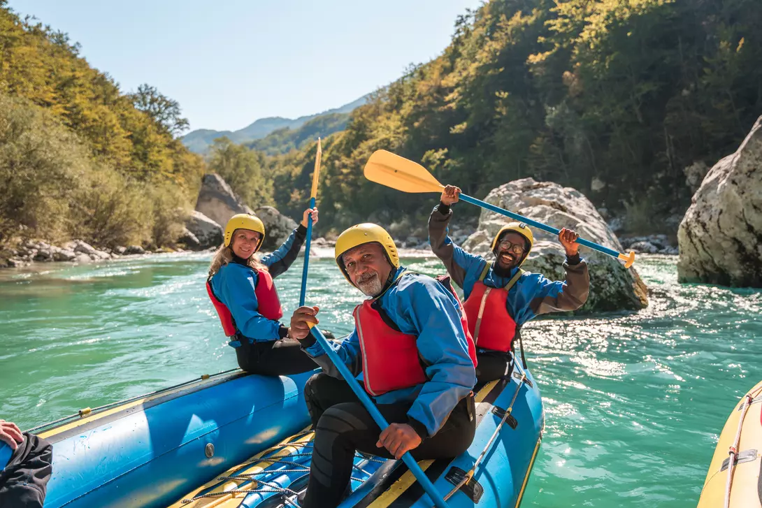 A group of people kayaking on a river in Slovenia