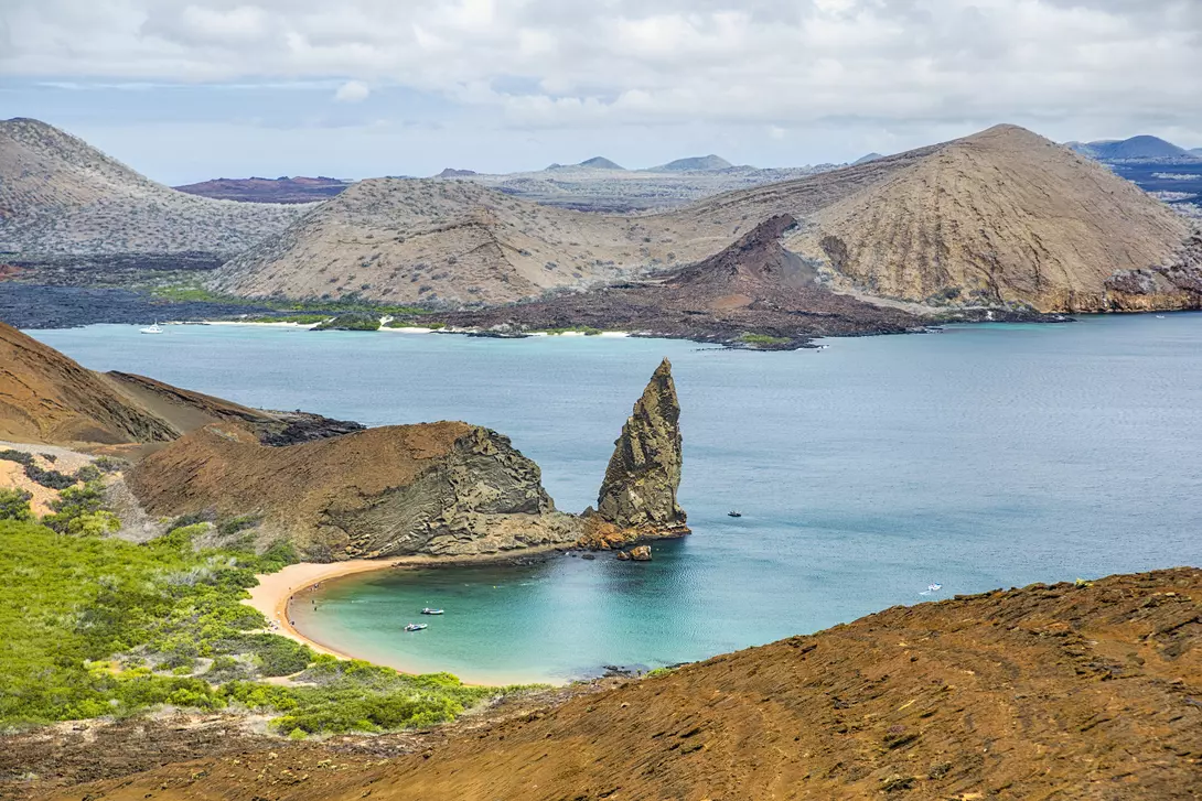 Aerial view of the famous Pinnacle Rock on the small island of Bartolome, Galapagos, Ecuador. In the background is Santiago island.