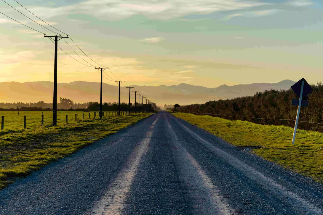 Sunset draws closer on a road running towards the Southern Alps, on New Zealand's South Island