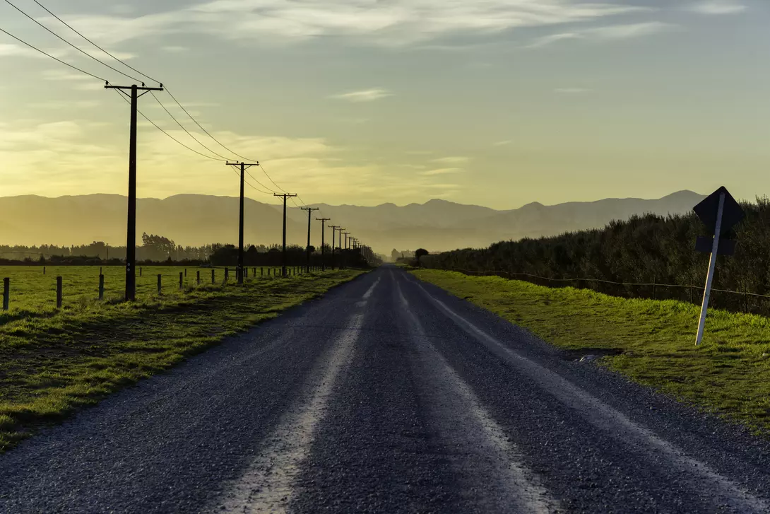 Sunset draws closer on a road running towards the Southern Alps, on New Zealand's South Island