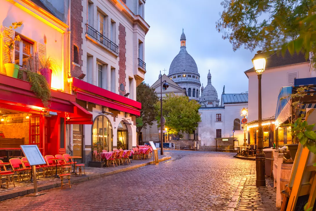 The Place du Tertre with tables of cafe and the Sacre-Coeur in the morning.