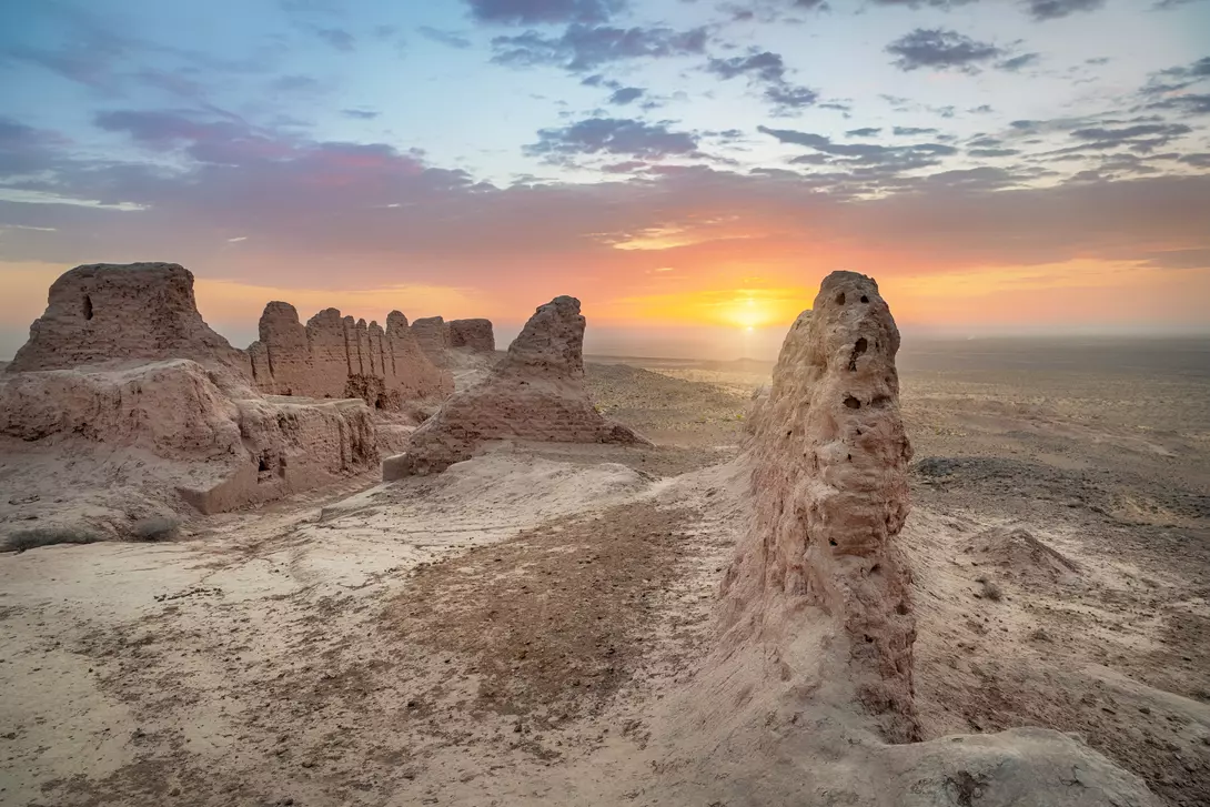 Ruins of ancient Khorezm fortress Ayaz Kala in Kyzylkum desert on sunrise