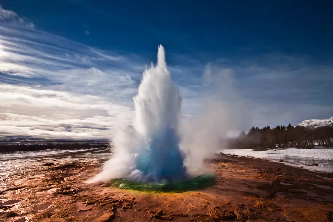 Erupting Strokkur Geyser on a sunny day in Iceland.