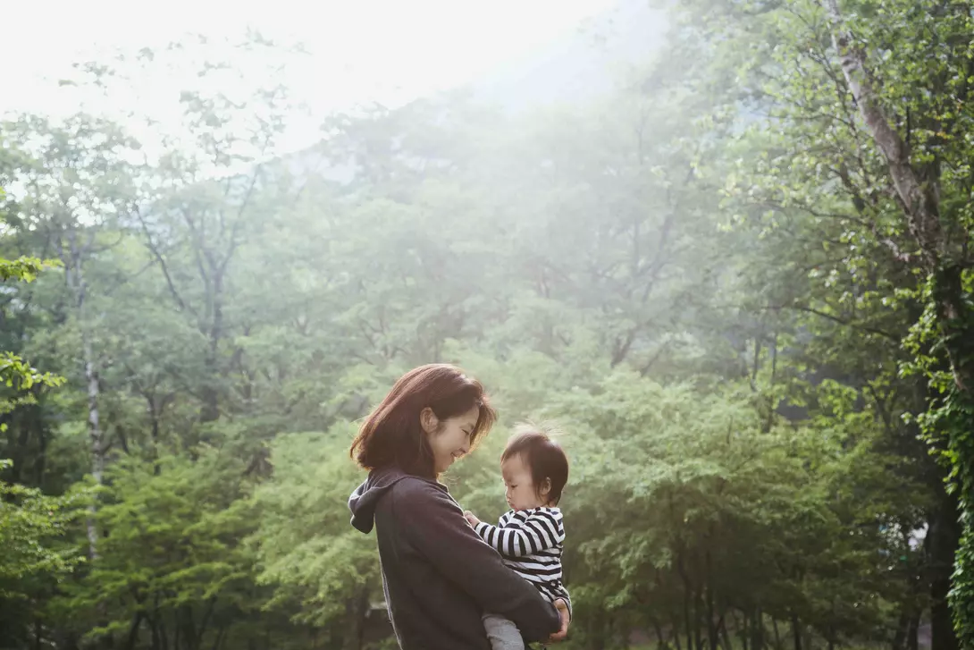 Mother carrying her baby girl in the mountain.