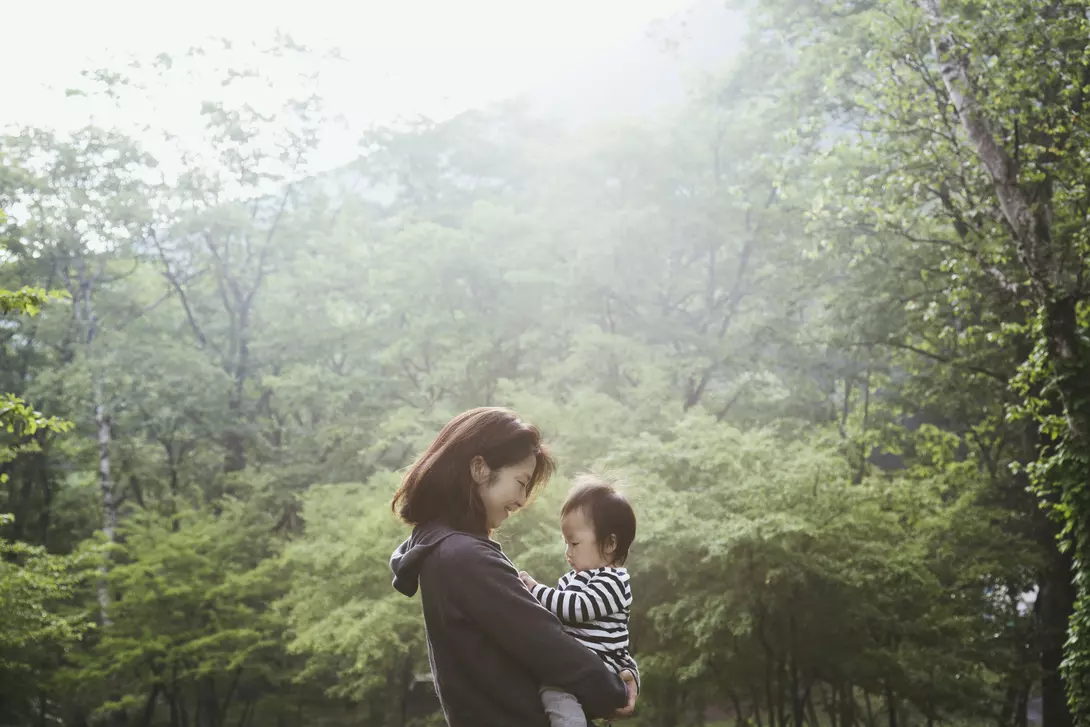 Mother carrying her baby girl in the mountain.