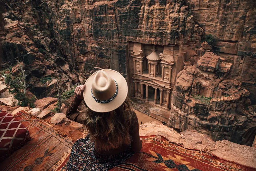 woman sitting on edge of cliff overlooking Petra