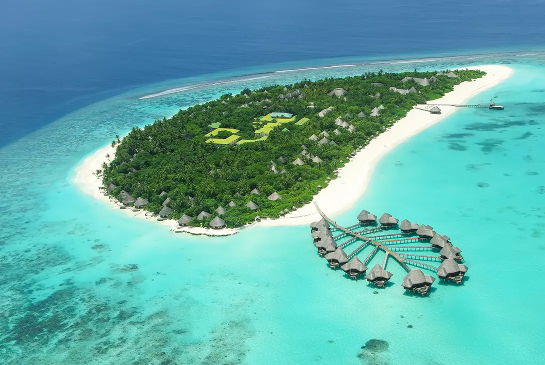 aerial view of overwater bungalows and white-sand beach island