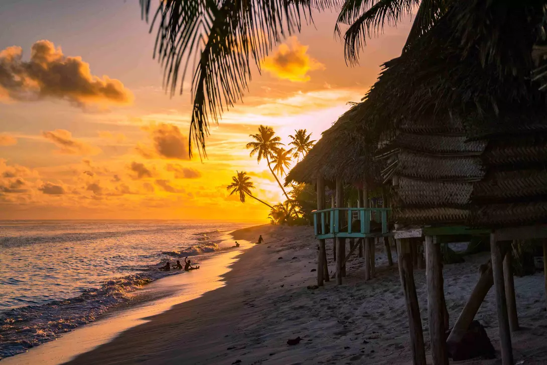 beach bungalows during sunset with ocean calmly lapping the sand