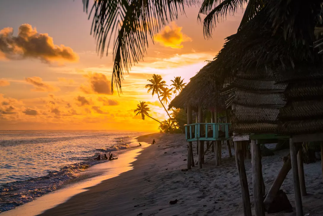 beach bungalows during sunset with ocean calmly lapping the sand