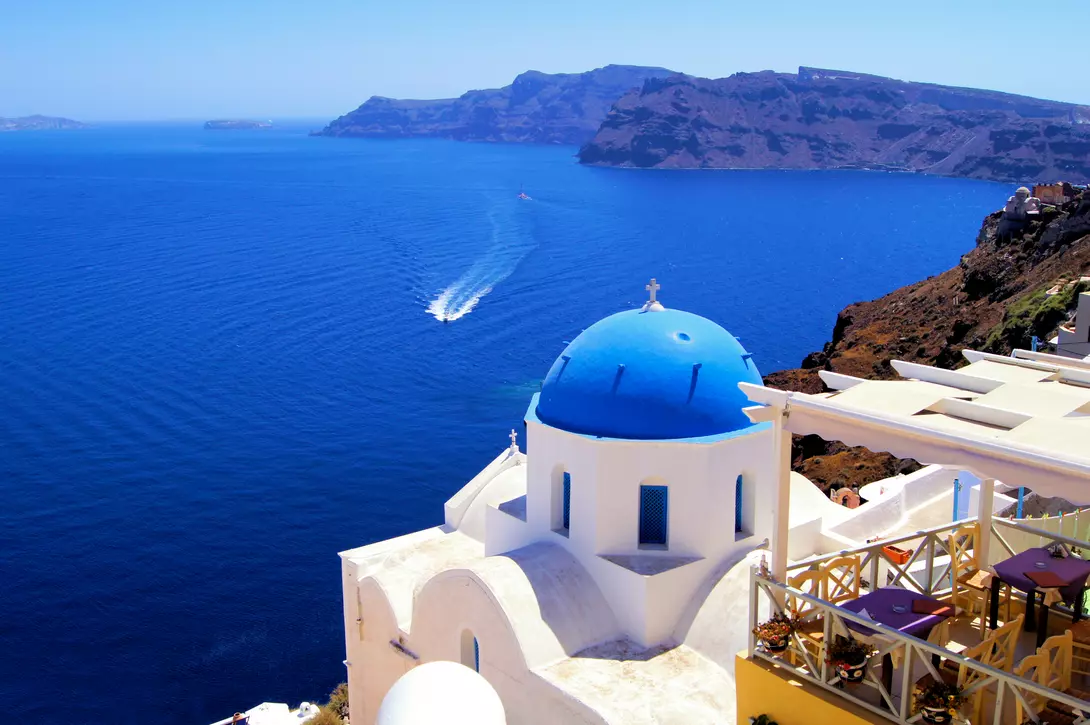 Blue dome church with boat, Oia village, Greece