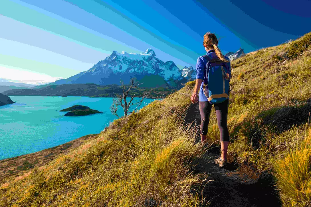 Woman hiker walks on the trail in the Torres del Paine National Park. Chile