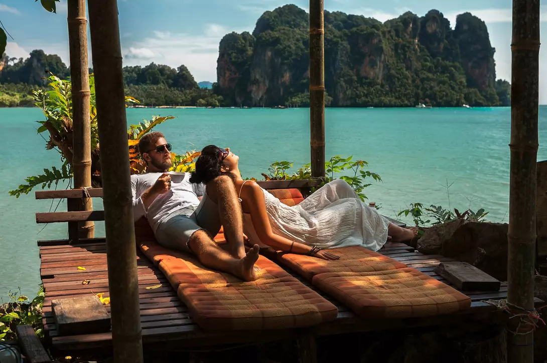 couple lounging alongside the blue waters of southern Thailand