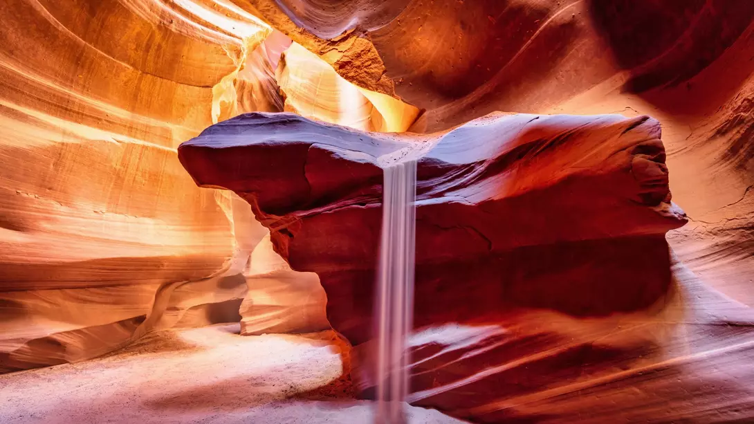 Sandfall, beautiful natural phenomenon inside the majestic Antelope Canyon in early morning light.