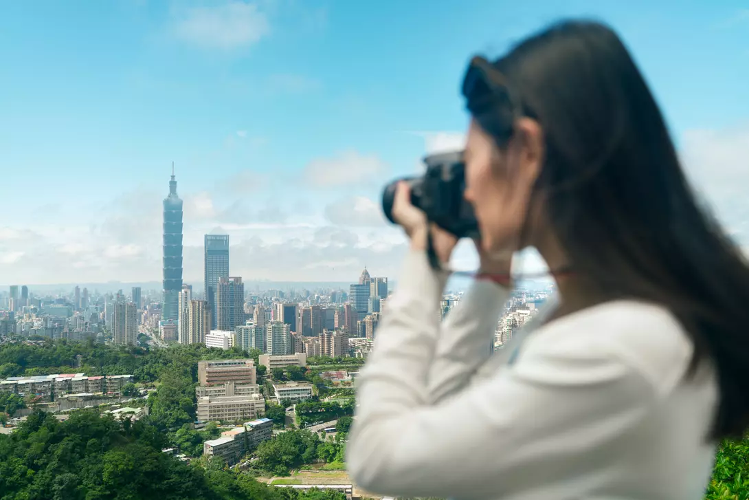 Traveler taking photos of among skyscrapers