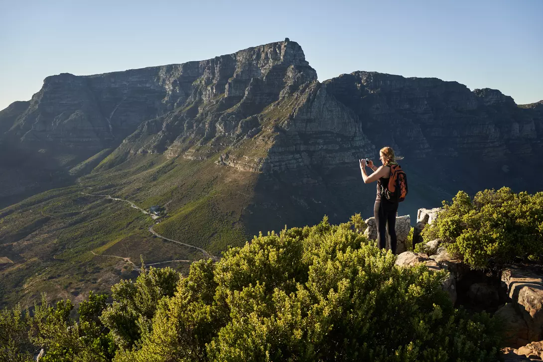 Woman hiker standing on the mountain ridge