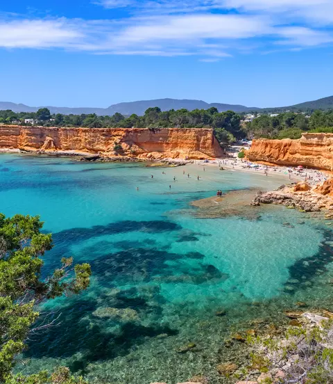 Bright light of a summer noon, transparent waters marbled with Posidonia meadows, sparse bathers on the beach.